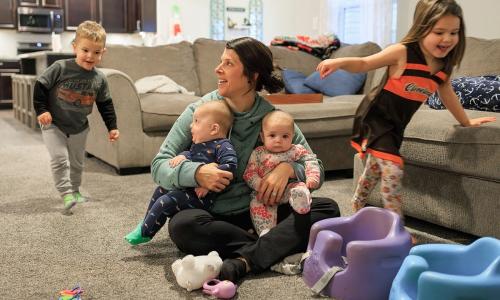 Mother and her four children play in the living room
