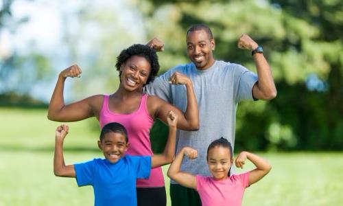 Family smiles and flex arms together