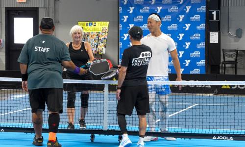 Pickleball players touch paddles after a game