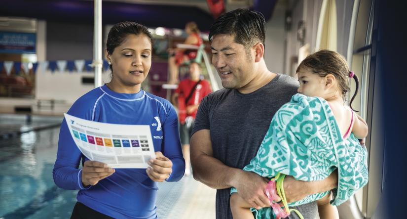 Swim instructor speaking to parent and child 
