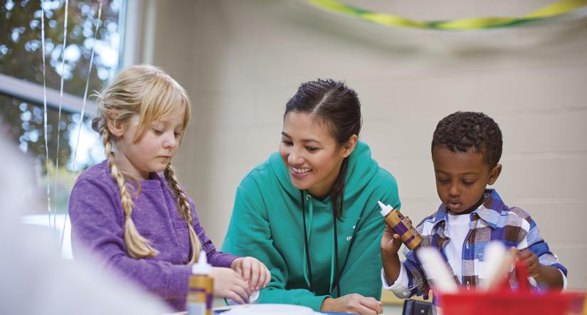 Child care staff doing arts and crafts with children 