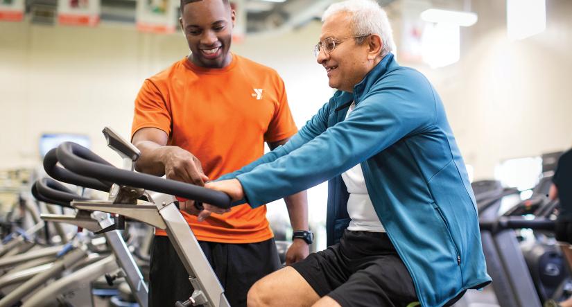 Personal trainer with man on bike
