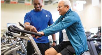 Personal Trainer guiding member on an exercise machine
