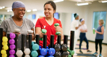 Y Staff and older member grabbing weights for exercise class