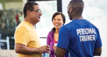 YMCA personal trainer talking with two members