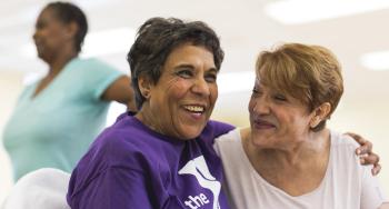 2 Women smiling, one in YMCA tshirt