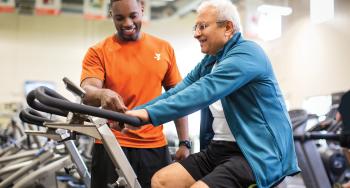 Personal trainer with man on bike