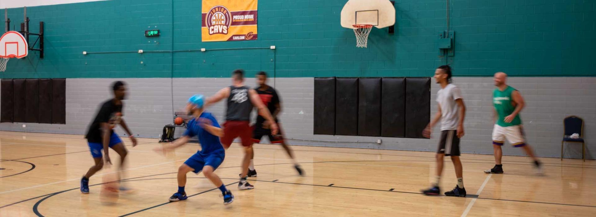 Image shows members playing a competitive game of basketball.